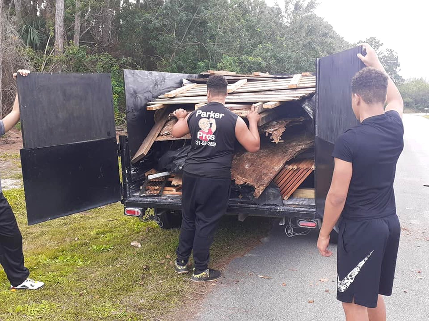 Crew loading lumber into the dump trailer