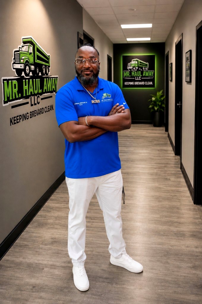 Anthony Mitchell Jr., owner of Mr. Haul Away, arms crossed in the company office