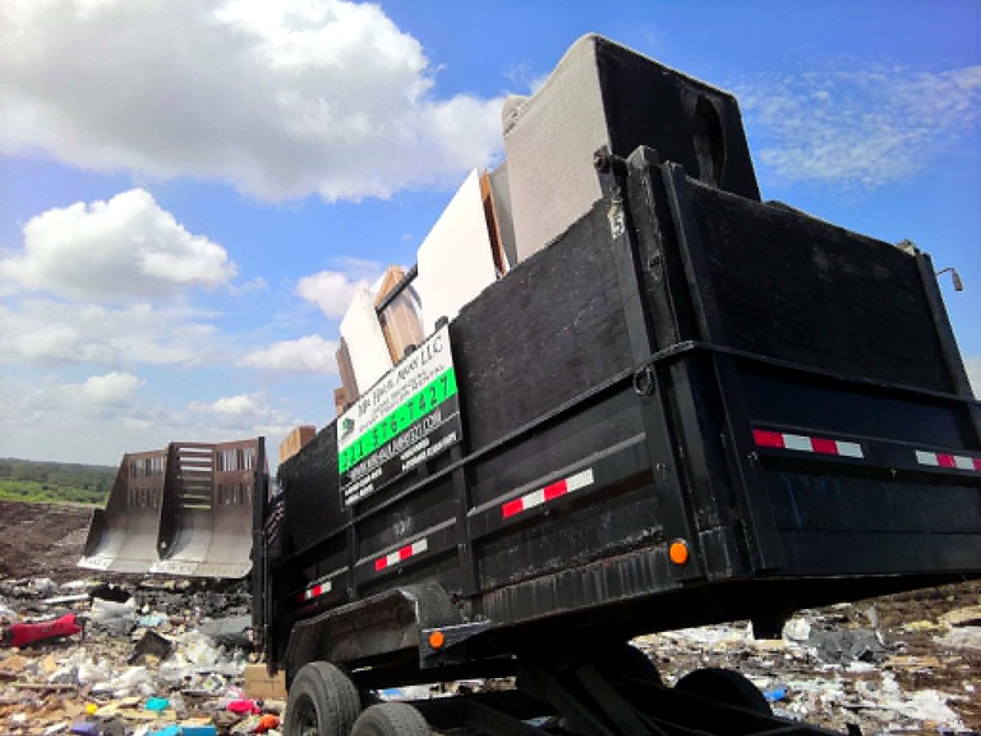 Mr. Haul Away trailer raised and dumping at the county landfill